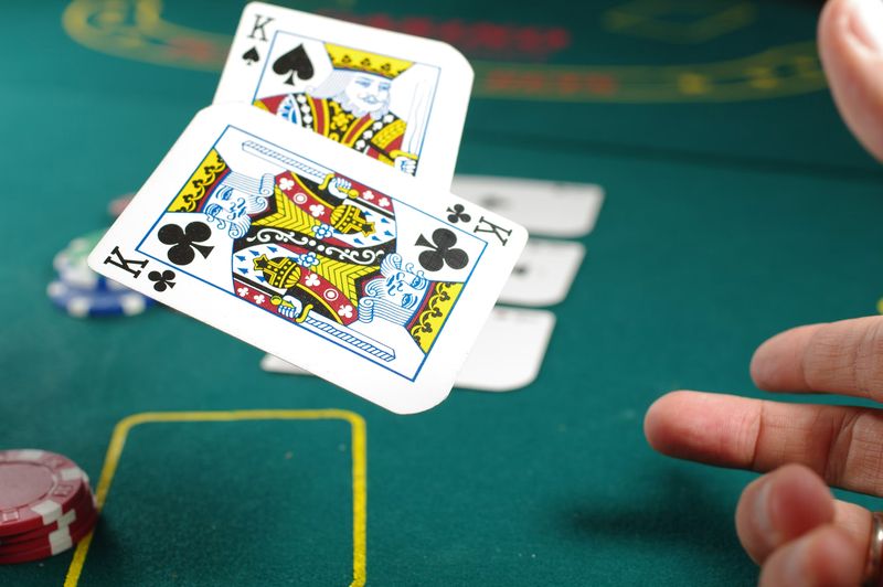 Two kings dealt face-up on a green felt table with poker chips